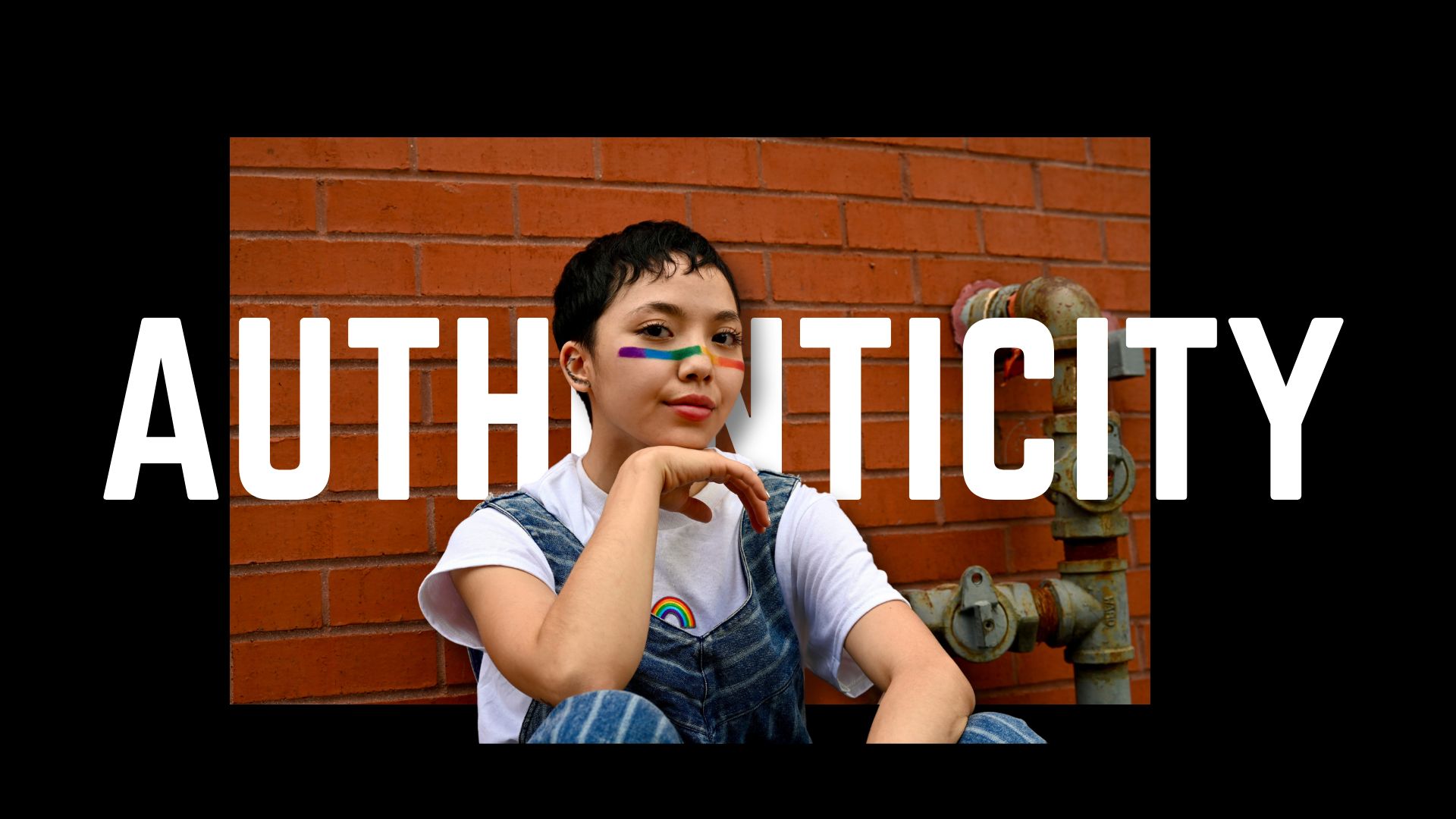 The word "Authenticity" with a photo of a young queer person being themself.